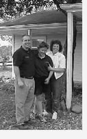 Tom, Shelley and Esther Urban stand in front of a porch.