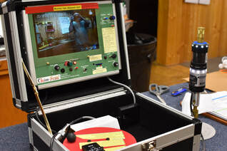 A Chim-Scan Controller with Monitor shows a clear image while a Lighthouse Camera is neaby.  