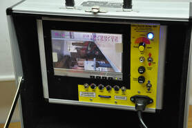 An image is shown on a color monitor housed in a case with switches and controls.